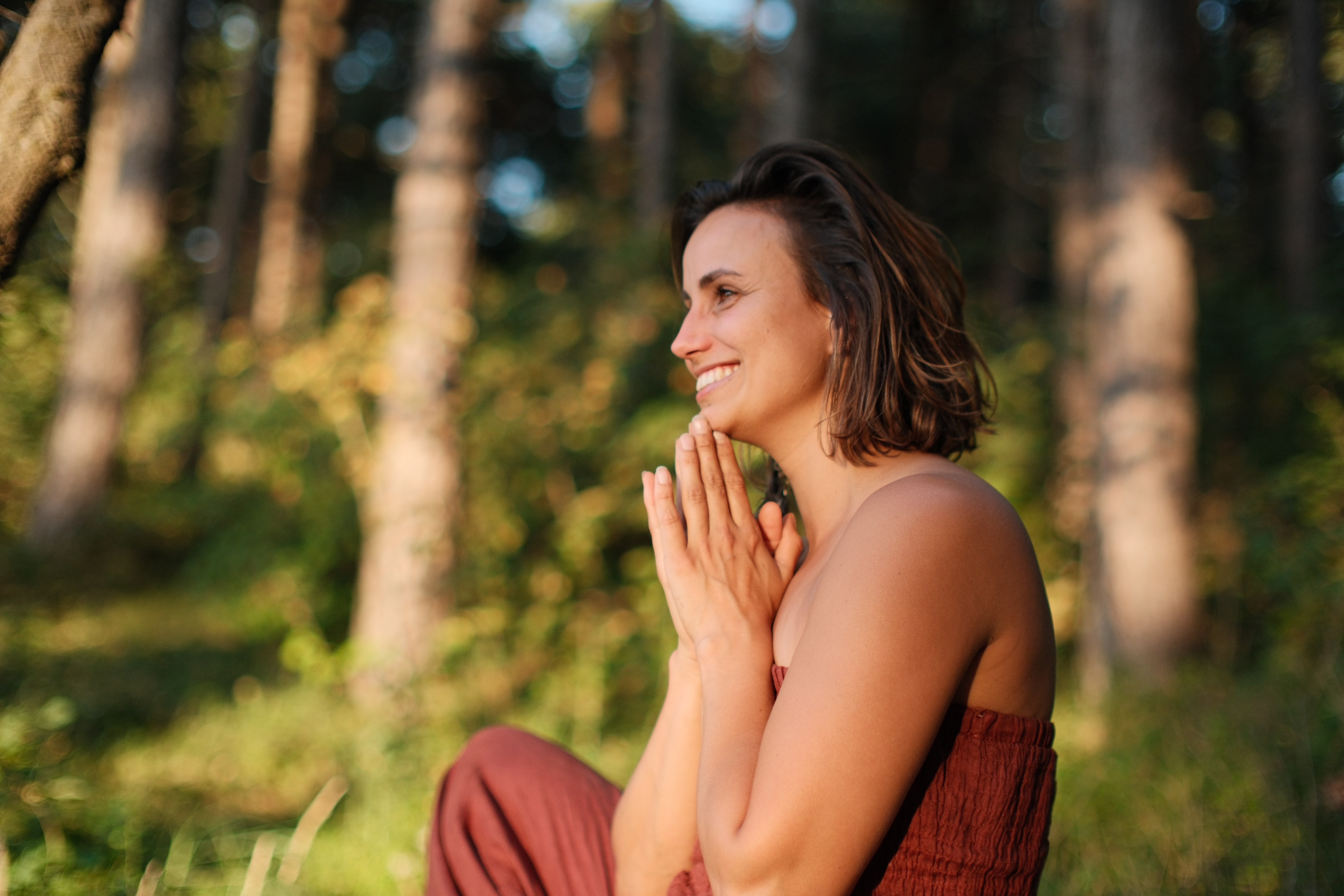 Daphne glimlachend in warm licht tussen de bomen
